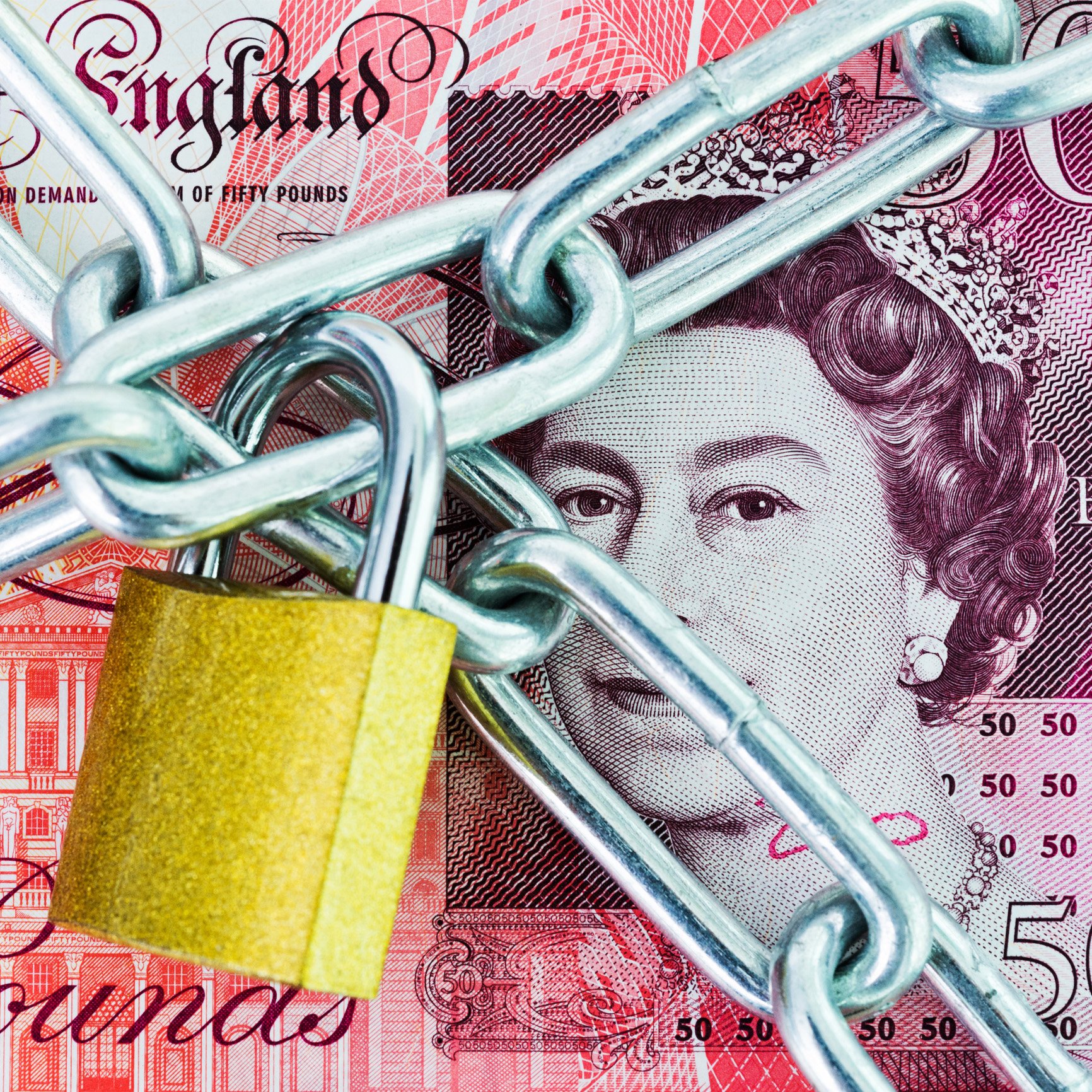 British money covered with padlock and chains