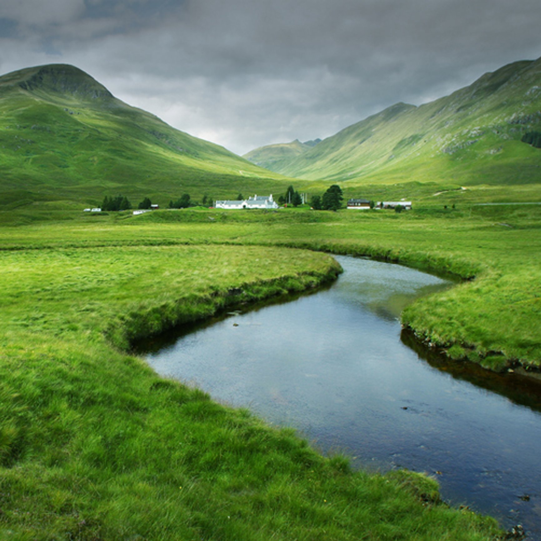 Peaceful flowing river through green hillside