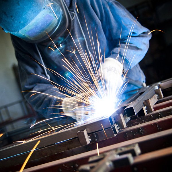 Worker creating sparks whilst cutting metal