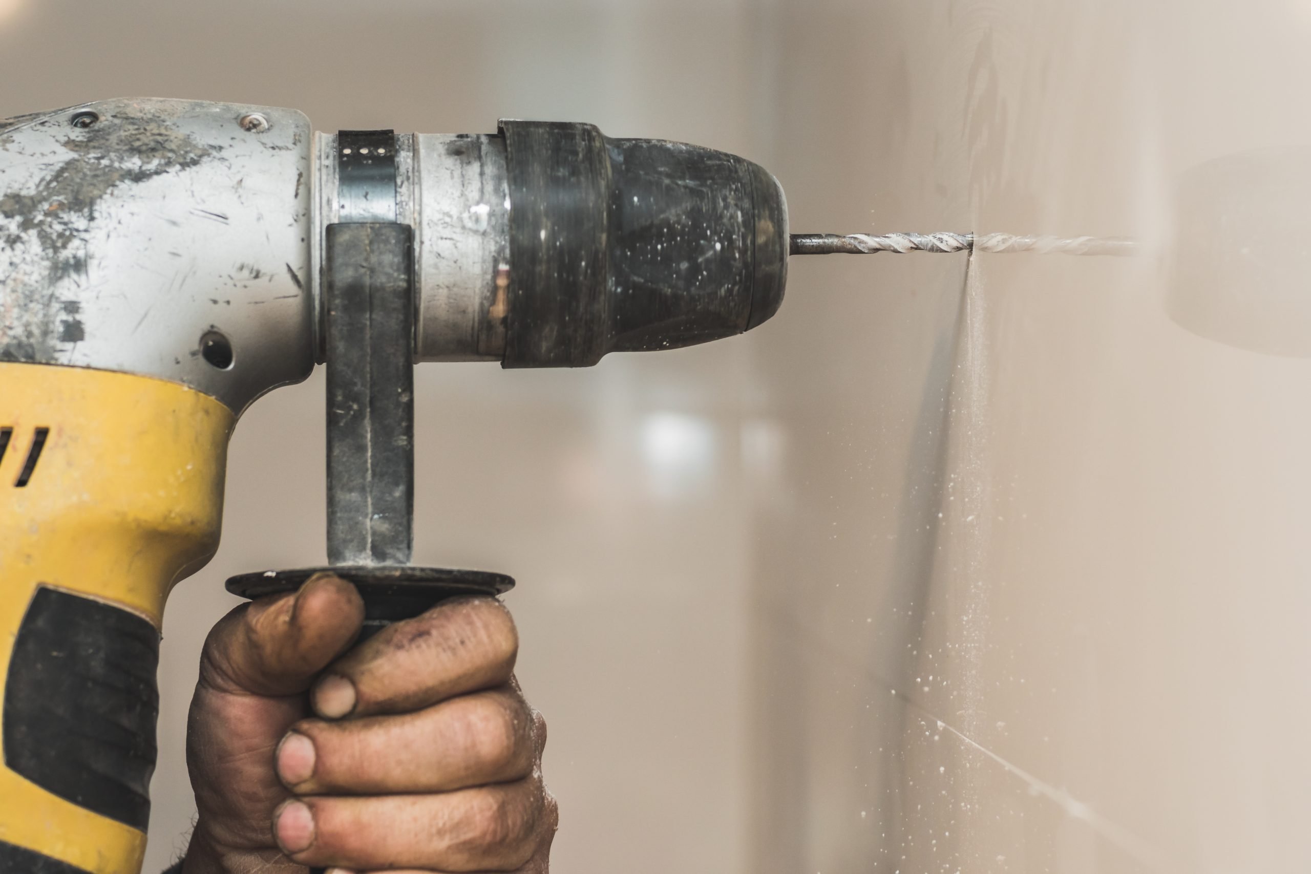 Man drilling into a tile wall