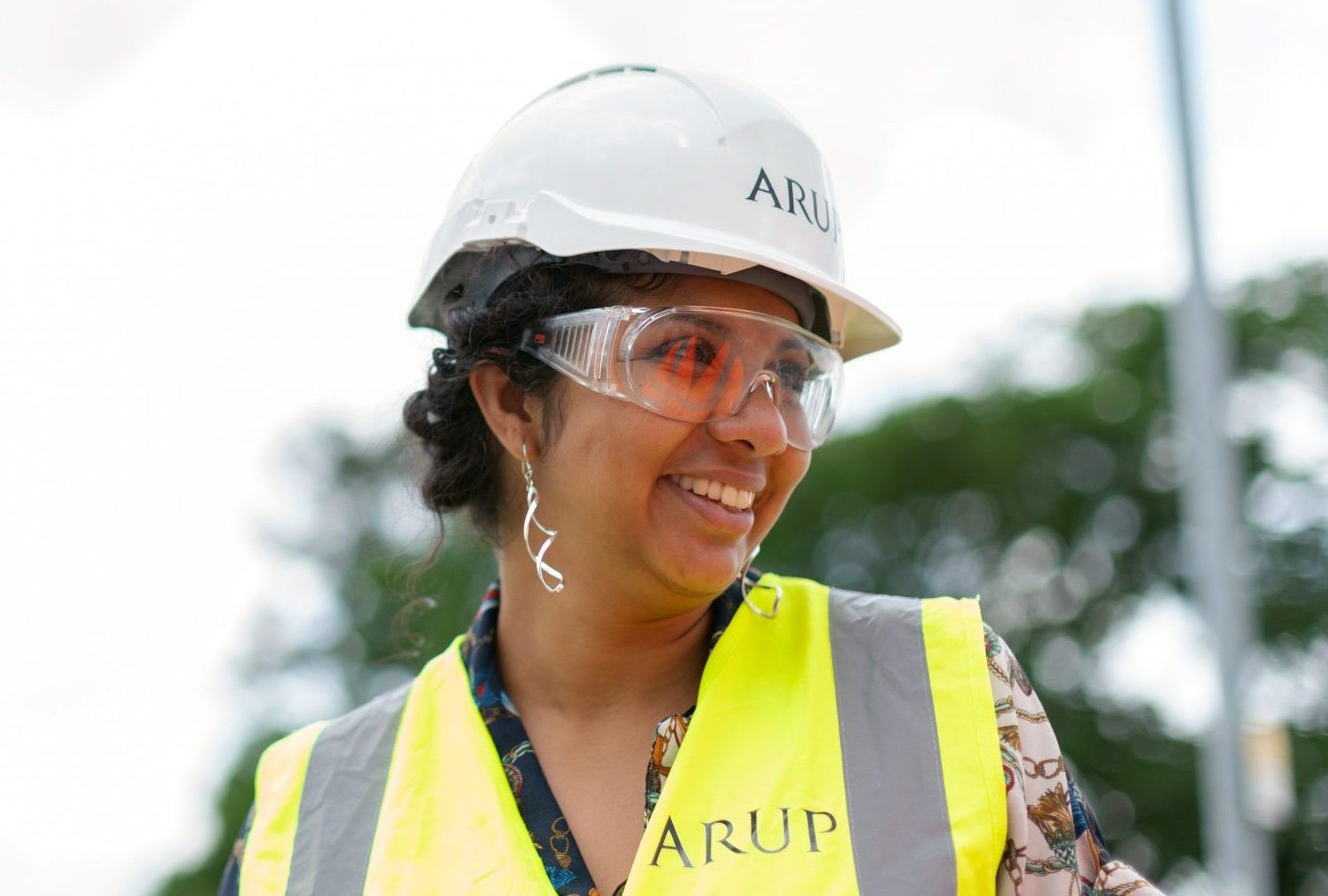 smiling female engineer in hardhat with hi vis jacket