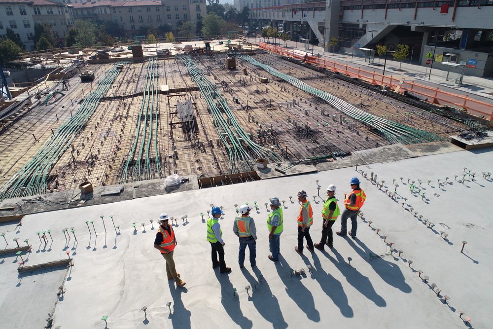Group of workers overlooking large building foundations